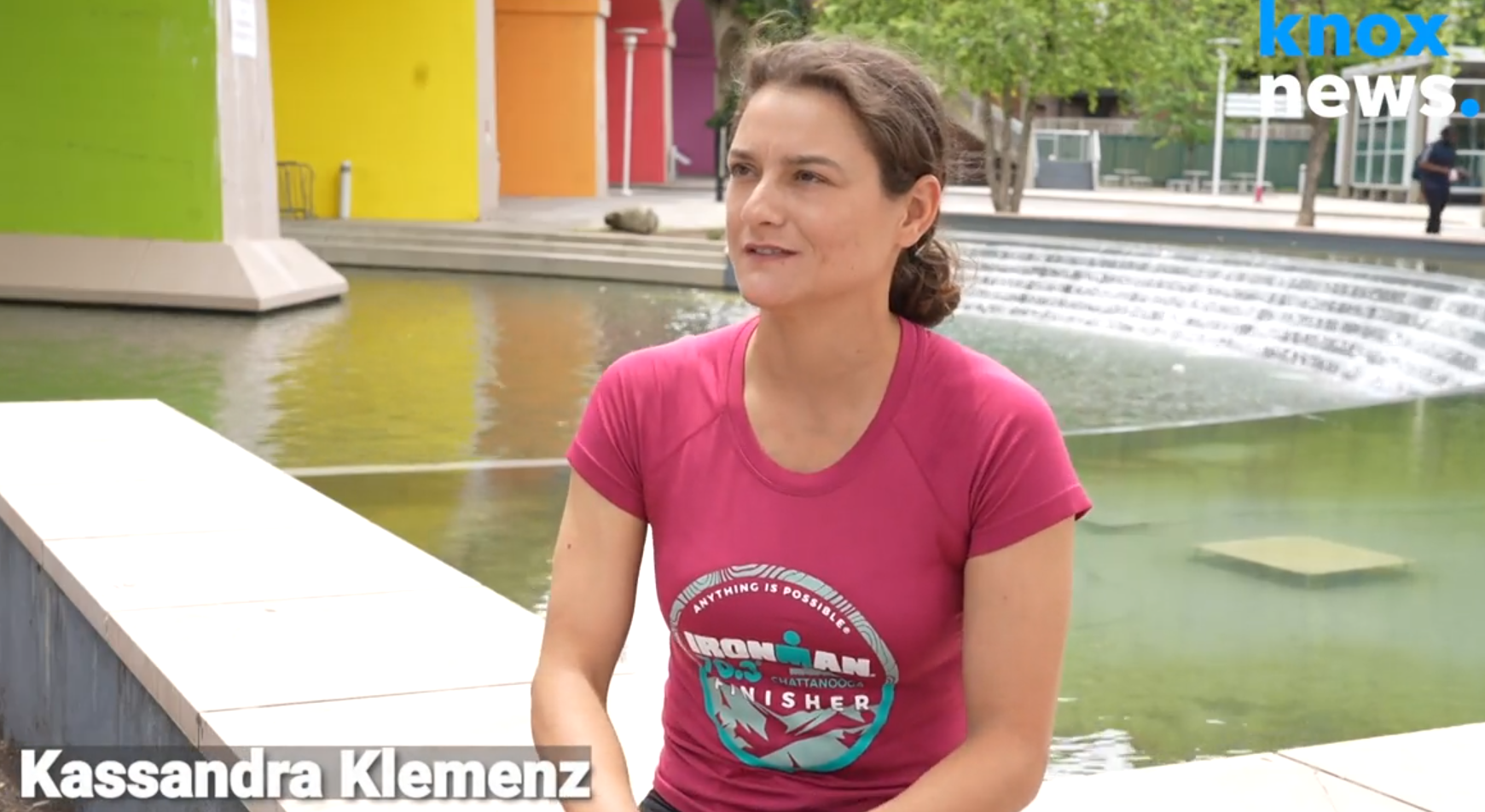 Kassandra sits in front of a water fountain for an interview.